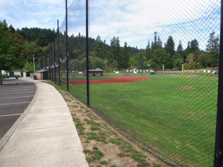 Baseball field along entrance road with sidewalk and accessible restrooms